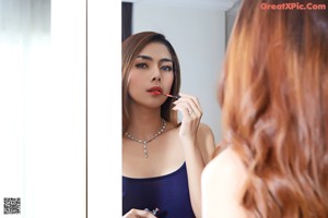 A woman in a black lingerie posing in front of a closet.