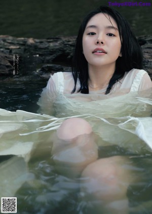 A woman in a white dress standing in the rain.