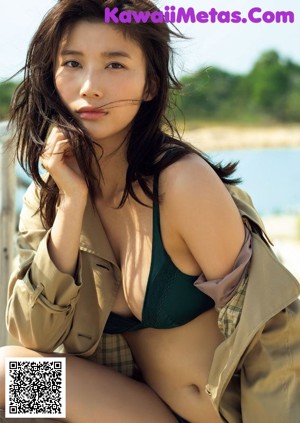 A woman in a black suit is posing for a magazine.