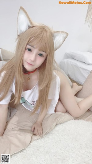 a woman sitting on top of a bed next to a pillow