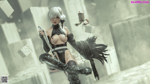 A woman in a black outfit holding a sword.
