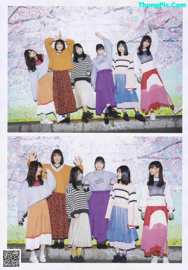 A group of young women posing for a photo in front of a wall.