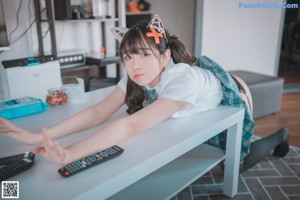 A woman in a school uniform is sitting on a table.