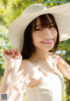 A woman in a white dress posing for a picture.