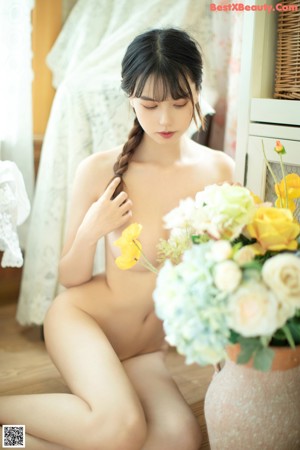 A young woman sitting on the floor holding a stuffed animal.