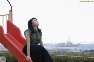 A woman standing on top of a building looking up at the sky.