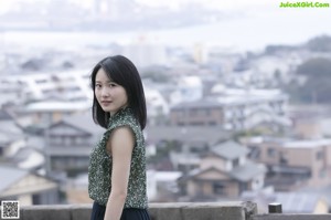 A woman standing on top of a building looking up at the sky.