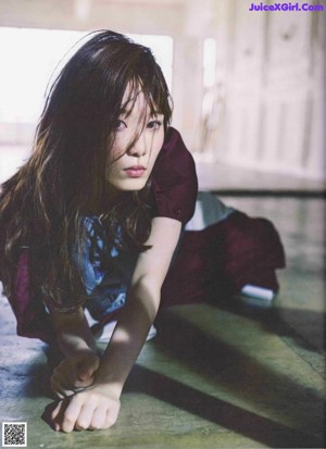 A magazine spread with a woman laying on the floor.