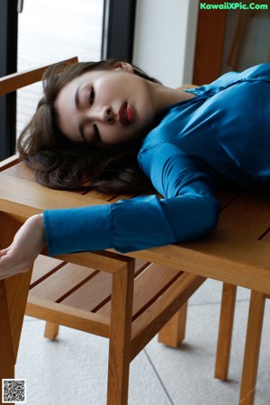 A woman wearing a blue shirt and a blue skirt.