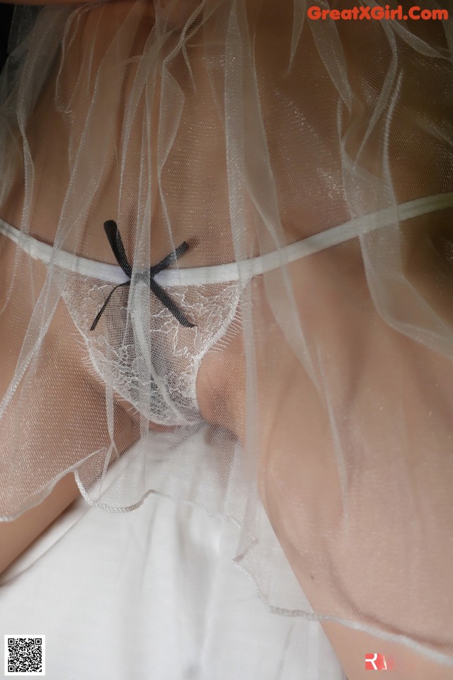 A close up of a woman wearing a white lingerie.