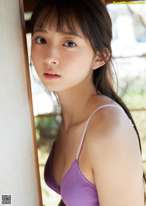 A woman in a pink dress posing for a picture.