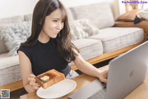 A woman laying on top of a couch next to a pillow.