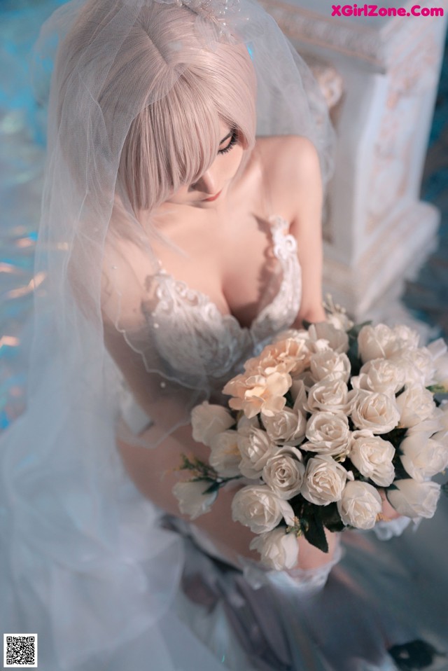 A woman in a wedding dress holding a bouquet of flowers.