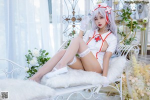 A woman dressed as a nurse sitting on a white chair.