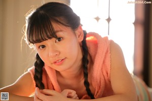 A young woman sitting on the floor with her legs crossed.