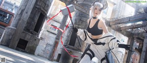 A woman dressed in a white and black outfit holding a sword.