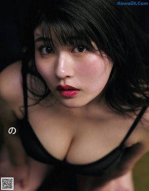A woman in a black lingerie laying on a couch.