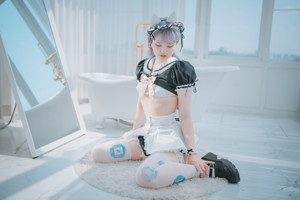 A woman in a white lingerie sitting on a bed.