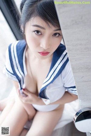A woman in a black lingerie sitting on a window sill.