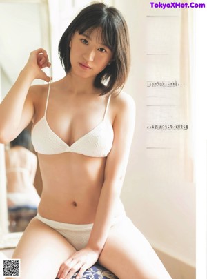 A woman in a white bra is posing for a picture.