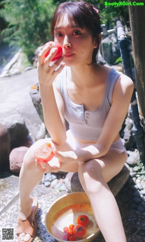 A woman in a white bathing suit standing in the water.