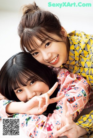 A couple of young women sitting next to each other.