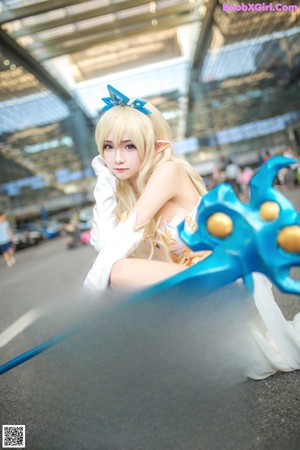 A woman dressed in a white and blue outfit holding a sword.