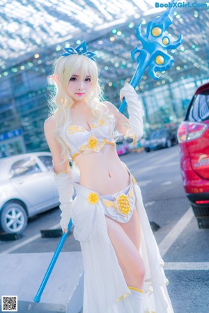 A woman in a white dress holding a blue sword.
