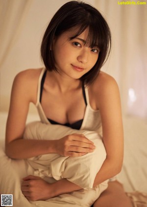 A woman in a colorful dress sitting on the edge of a pool.