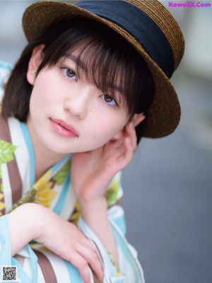 A woman wearing a sunflower kimono and a straw hat.
