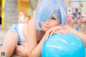 A woman in a blue bikini sitting on the ground.