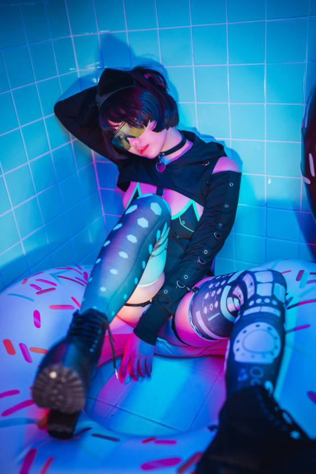 A woman sitting on top of an inflatable donut in a bathtub.